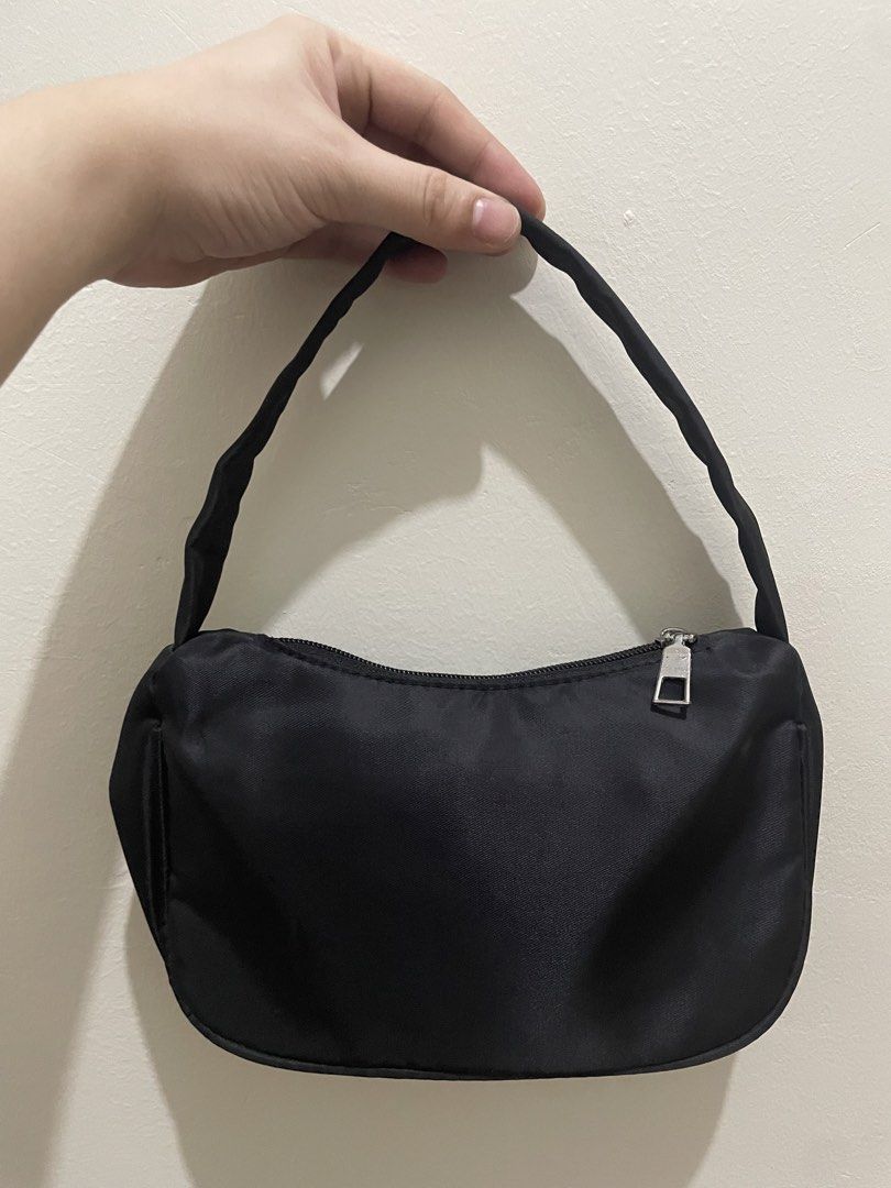 Black nylon shoulder bag with silver hardware (Category: Shoulder Bags) located in Guiguinto. Submitted by beatan13 (Listing ID 1466445228, Image 2). Description: - Black nylon shoulder bag with a trendy curved silhouette - Features iconic silver metal triangular plate on the front - Secure top zipper closure with clean interior lining and zipper pocket - Comfortable matching black fabric shoulder strap - Perfect size for daily essentials and nig