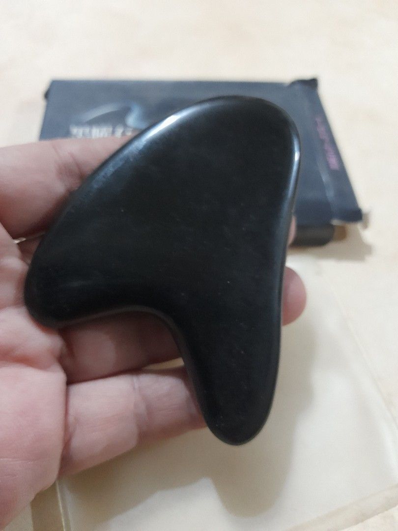 Black Obsidian Gua Sha Facial Tool with Box (Category: Face Care) located in Bocaue. Submitted by marajapansurplus (Listing ID 1466482914, Image 2). Description: - Product: Black Obsidian Gua Sha tool - Benefits: Reduces puffiness, relieves tension, and aids lymphatic drainage - Design: Smooth polished surface with ergonomic curves for face and neck - Condition: Clean, well-maintained - Inclusions: Original black retail box and protective sleeve 