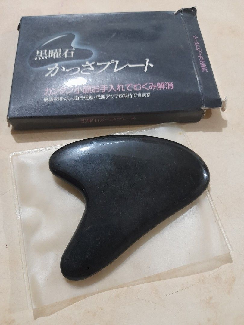 Black Obsidian Gua Sha Facial Tool with Box (Category: Face Care) located in Bocaue. Submitted by marajapansurplus (Listing ID 1466482914, Image 1). Description: - Product: Black Obsidian Gua Sha tool - Benefits: Reduces puffiness, relieves tension, and aids lymphatic drainage - Design: Smooth polished surface with ergonomic curves for face and neck - Condition: Clean, well-maintained - Inclusions: Original black retail box and protective sleeve 