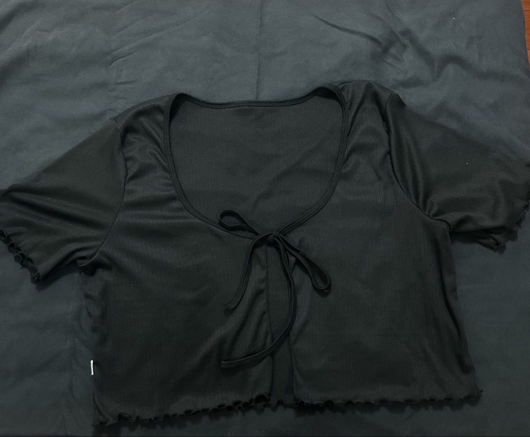 Black ribbed short sleeve crop top with front tie (Category: Shirts) located in Manila. Submitted by ericafelize23 (Listing ID 1466455879, Image 1). Description: - Color: Classic Black - Style: Ribbed crop top with short sleeves - Neckline: Scoop neck with an adjustable tie-front closure - Details: Trendy lettuce hem on sleeves and bottom edge - Material: Soft and stretchy fabric for all-day comfort - Condition: Brand new / Excellent quality - Pe
