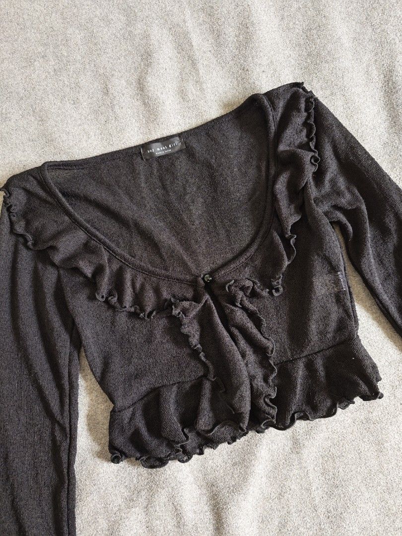 Black Ruffle Cardigan Top (Category: Longsleeves) located in Manila. Submitted by goku_doggo (Listing ID 1466364595, Image 2). Description: - Brand: BMG Boy Meet Girl (Made in Korea) - Style: Black knit cardigan with single button closure and scoop neckline - Details: Adorable frilly ruffle trim along the collar, placket, and hem - Material: Lightweight, slightly sheer knit - Size: Size F (Best fits Small to Medium).