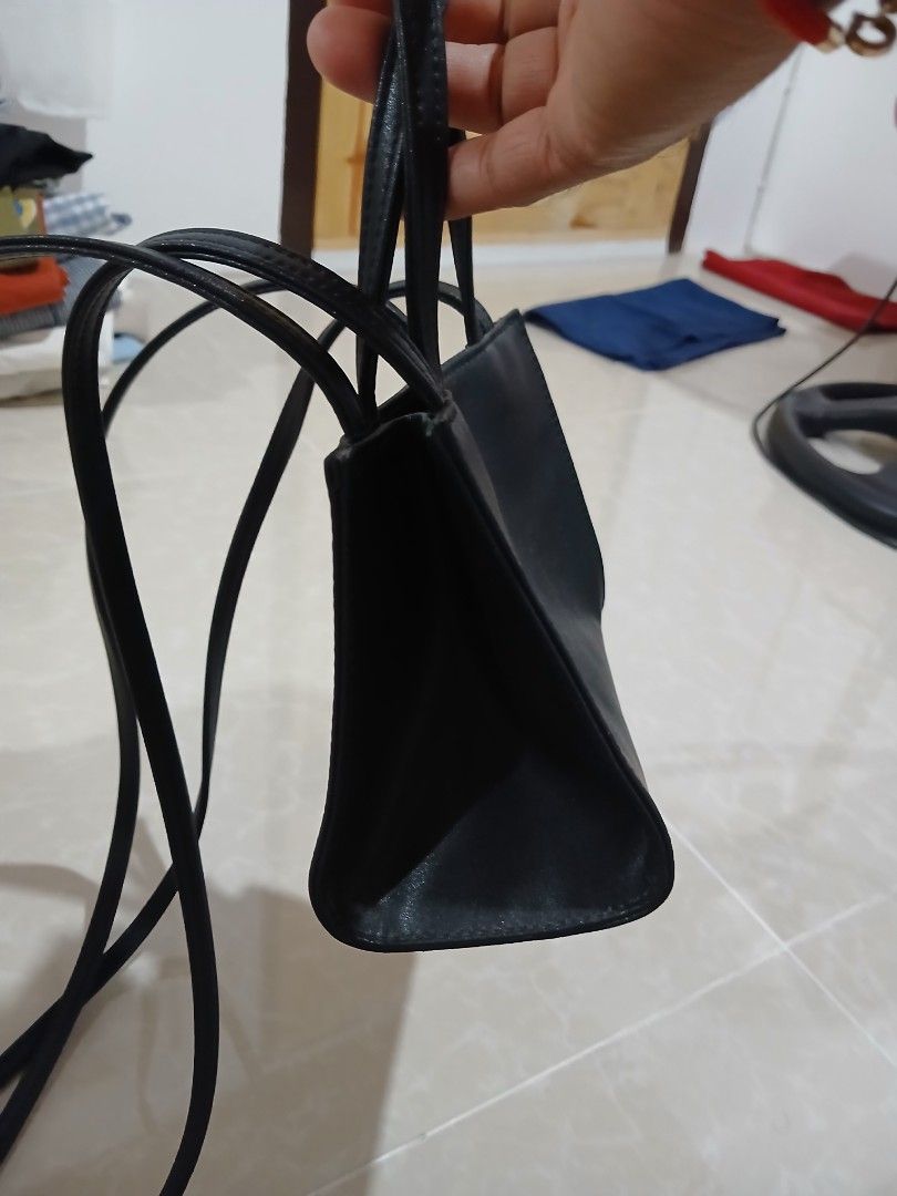 Black Telfar Shopping Bag (Category: Tote Bags) located in Quezon City. Submitted by mcenon35 (Listing ID 1466481282, Image 2). Description: - Color: Sleek Black - Design: Iconic embossed Telfar logo on the front - Versatile: Includes double top handles and a long crossbody strap - Interior: Fabric-lined with official branding tag - Closure: Secure magnetic snap closure - Size: Compact, ideal for everyday essentials - Condition: Brand new / Excel