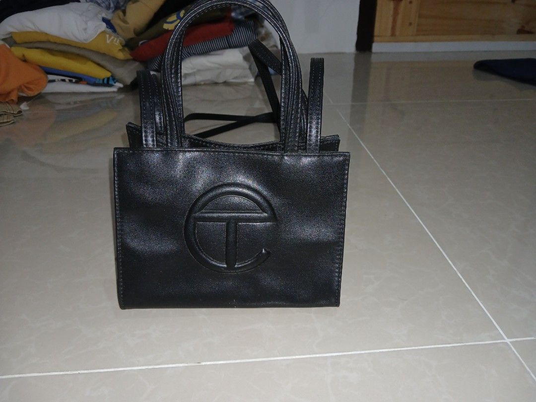 Black Telfar Shopping Bag (Category: Tote Bags) located in Quezon City. Submitted by mcenon35 (Listing ID 1466481282, Image 1). Description: - Color: Sleek Black - Design: Iconic embossed Telfar logo on the front - Versatile: Includes double top handles and a long crossbody strap - Interior: Fabric-lined with official branding tag - Closure: Secure magnetic snap closure - Size: Compact, ideal for everyday essentials - Condition: Brand new / Excel