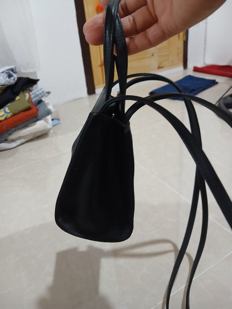Black Telfar Shopping Bag (Category: Tote Bags) located in Quezon City. Submitted by mcenon35 (Listing ID 1466481282, Image 3). Description: - Color: Sleek Black - Design: Iconic embossed Telfar logo on the front - Versatile: Includes double top handles and a long crossbody strap - Interior: Fabric-lined with official branding tag - Closure: Secure magnetic snap closure - Size: Compact, ideal for everyday essentials - Condition: Brand new / Excel