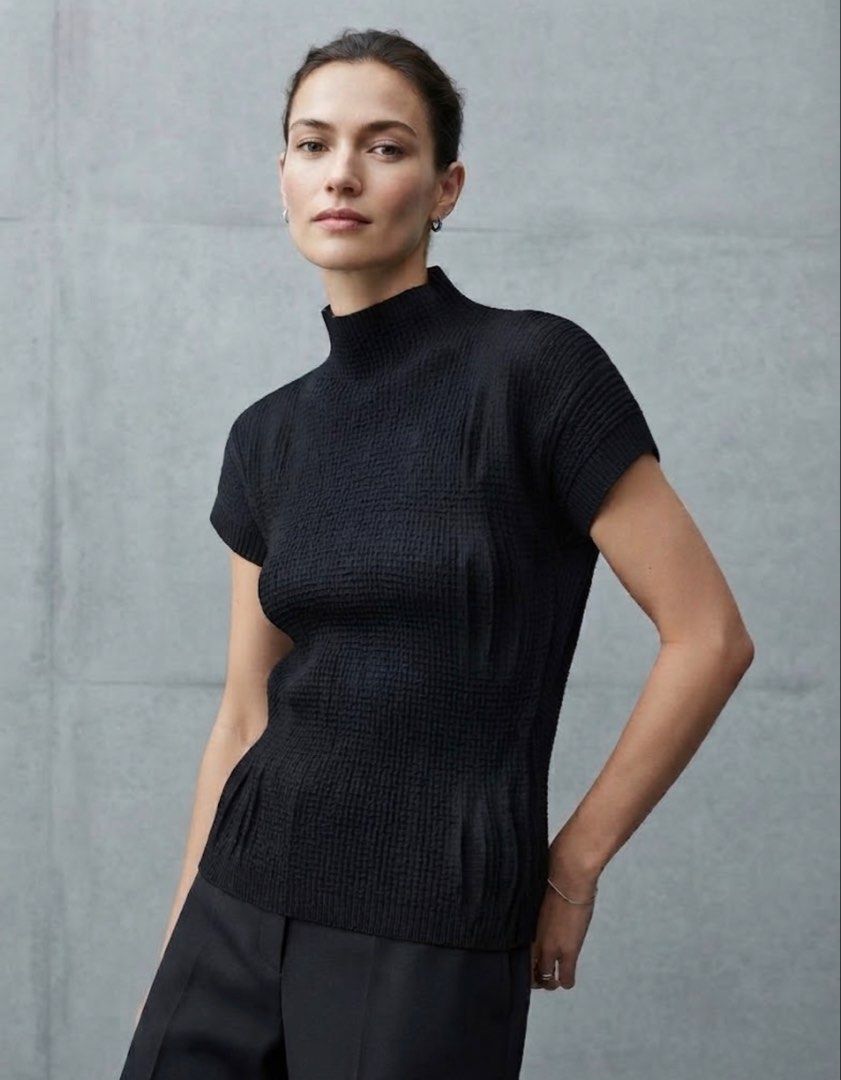 Black Waffle High Neck Short Sleeve Top (Category: Blouses) located in Donsol. Submitted by saksthriftavenuebyluckymaria8 (Listing ID 1466357215, Image 1). Description: - Color: Black - Material: Textured waffle knit fabric - Design: Mock neckline with subtle vertical front panels - Sleeves: Cap sleeves with ribbed cuffs - Fit: Clean, minimal silhouette - Styling: Versatile piece, easy to pair with denim or trousers Sz L chest 22in length 25in. S