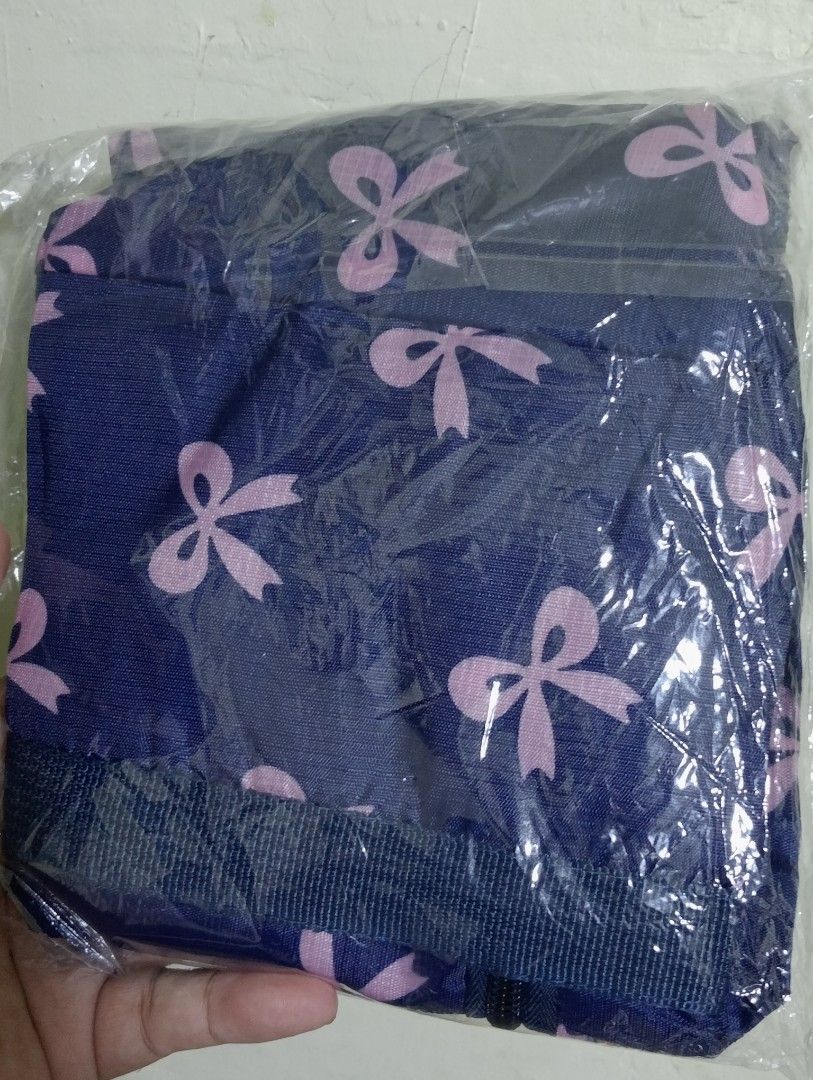 Blue Bow Print Travel Duffle Bag (Category: Activewear) located in Makati City. Submitted by redisell (Listing ID 1466337255, Image 3). Description: - Color & Pattern: Navy blue with an all-over pink bow pattern - Dimensions: 44.5cm x 30cm x 13cm (12cm handle drop) - Features: Front zipped pocket for extra storage and foldable design that packs flat - Condition: Brand new, still sealed in original plastic packaging.