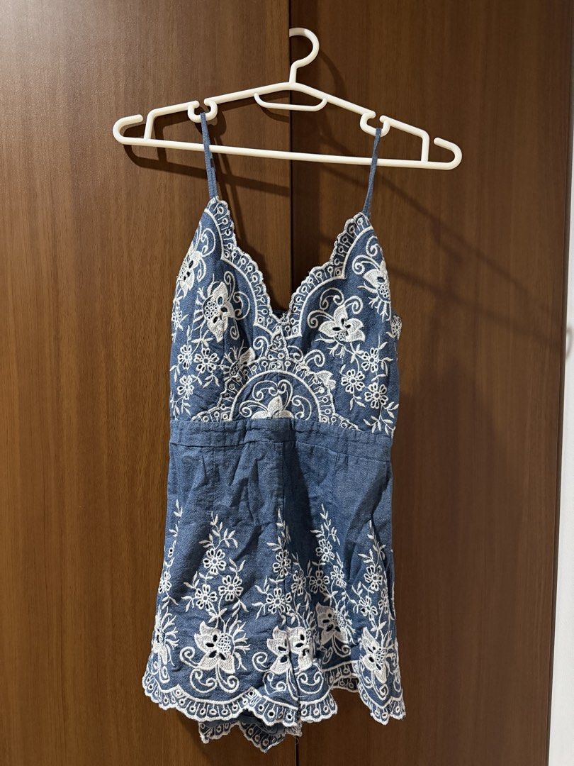 Blue denim romper with white embroidery spaghetti strap (Category: Rompers) located in Cebu City. Submitted by prelovedbymecebu (Listing ID 1466336912, Image 1). Description: - Style: Blue denim-look romper with white floral embroidery - Details: Spaghetti straps, scalloped V-neck, and scalloped hem shorts - Fit: Mid-waist seam, lightweight and comfortable - Occasion: Perfect for casual days out or beach trips.