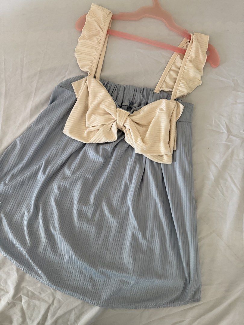 Blue Ribbed Top with Cream Ruffle Straps and Bow (Category: Sleeveless) located in Santa Rosa. Submitted by itskllycstll (Listing ID 1466402870, Image 1). Description: - Color: Light blue with cream accents - Material: Stretchy ribbed fabric for a comfortable fit - Design: Sweet cream ruffles on shoulder straps and a large front bow - Length: Approx. 18 inches from top of shoulder - Style: Easy slip-on piece, perfect and comfy for warm weather 📍
