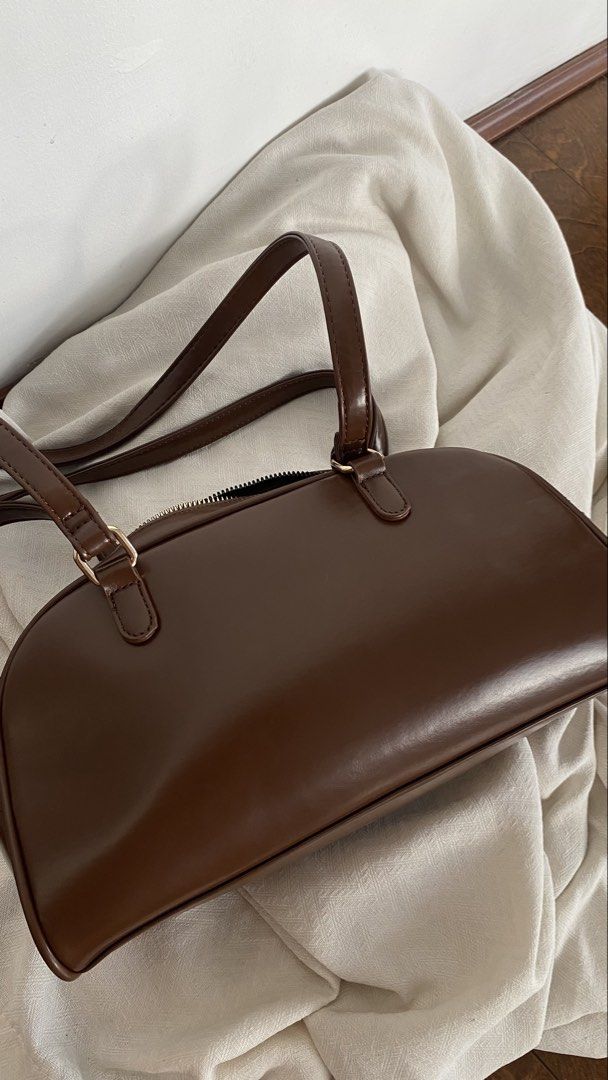 Bostanten Brown Shoulder Bag With Front Pockets (Category: Luxury Bags & Wallets) located in Manila. Submitted by poliin (Listing ID 1466430434, Image 3). Description: - Brand: Bostanten - Color: Dark brown - Material: Smooth faux leather with chic gold hardware - Closure: Secure top zip closure with double top handles - Pockets: Two convenient front pockets with snap button closures, plus an interior zipper pocket - Interior: Clean black fabric 