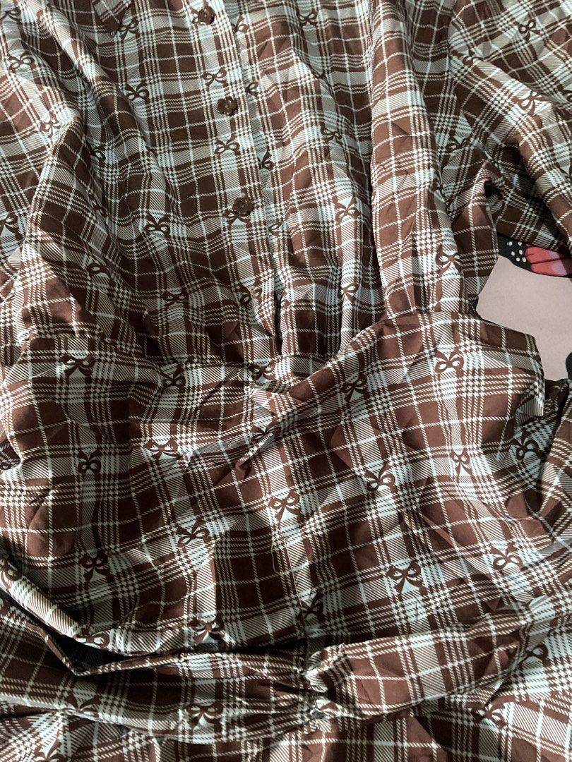 Brown and light blue plaid mini dress with bow pattern (Category: Dresses) located in Manila. Submitted by horangborahae (Listing ID 1466389583, Image 2). Description: - Brown and light blue plaid long sleeve mini dress - Features a button-down front with a classic collar - Flared skirt with a flattering gathered waistline - Cute, subtle all-over bow print on the fabric - Long sleeves with buttoned cuffs - Perfect and fun piece for casual days ou