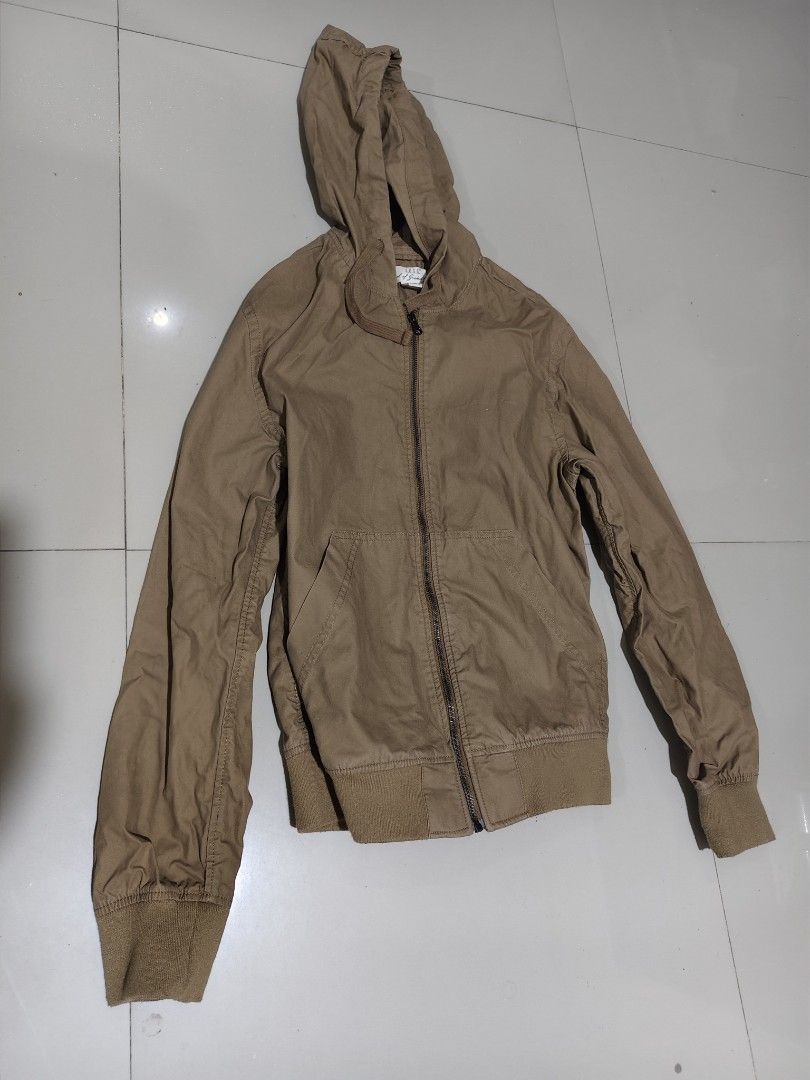 Brown Hooded Zip-Up Jacket with Ribbed Cuffs (Category: Coats, Jackets and Outerwear) located in Cavite. Submitted by kristiecasem (Listing ID 1466472119, Image 1). Description: - Color: Solid brown - Closure: Full front zipper - Hood: Adjustable with drawstrings - Pockets: Two slanted front pockets - Fit & Comfort: Ribbed hem and cuffs to block the wind - Material: Lightweight cotton blend - Style: Casual daily layer.