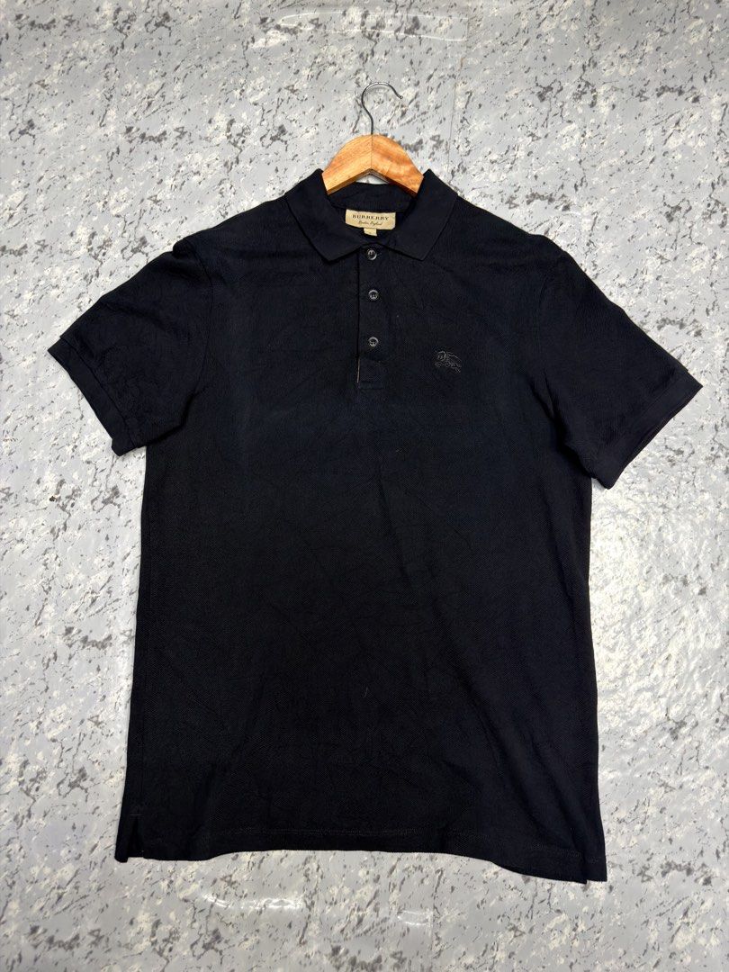 Burberry Black Polo Shirt (Category: Tshirts & Polo Shirts ) located in Manila. Submitted by raven236 (Listing ID 1466469381, Image 1). Description: - Brand: Burberry - Color: Solid black - Size: Available in standard fit (PM for exact measurements) - Material: Premium cotton - Features: Short sleeves, classic collar, 3-button placket, ribbed cuffs and collar - Logo: Iconic embroidered equestrian knight on left chest - Condition: Excellent / Clea