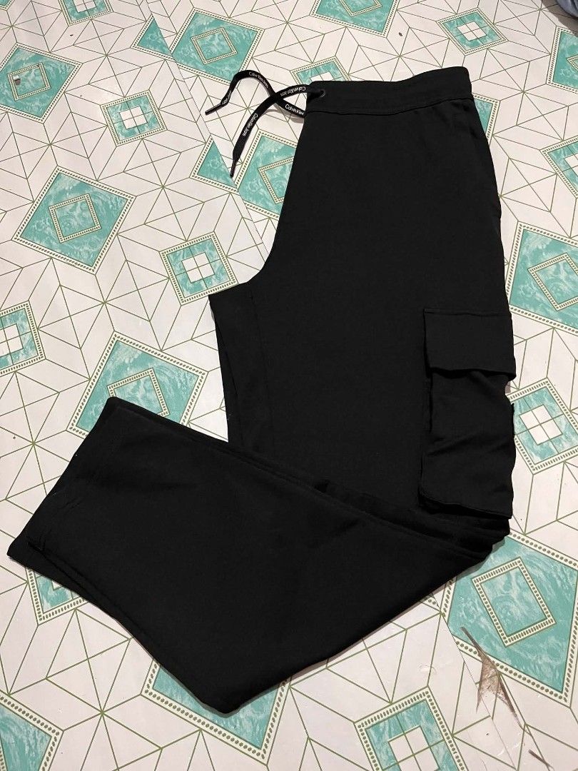 CALVIN KLEIN CARCO PANTS (Category: Joggers) located in Iloilo. Submitted by _lemornosnas02 (Listing ID 1466491277, Image 2). Description: Calvin Klein Jeans black cargo joggers featuring a side cargo pocket with the signature "CK" logo patch +SIZE SMALL ON TAGS +DIMES 16x36 +no issue good as new 10/10 +location iloilo +plus ship via lbc.
