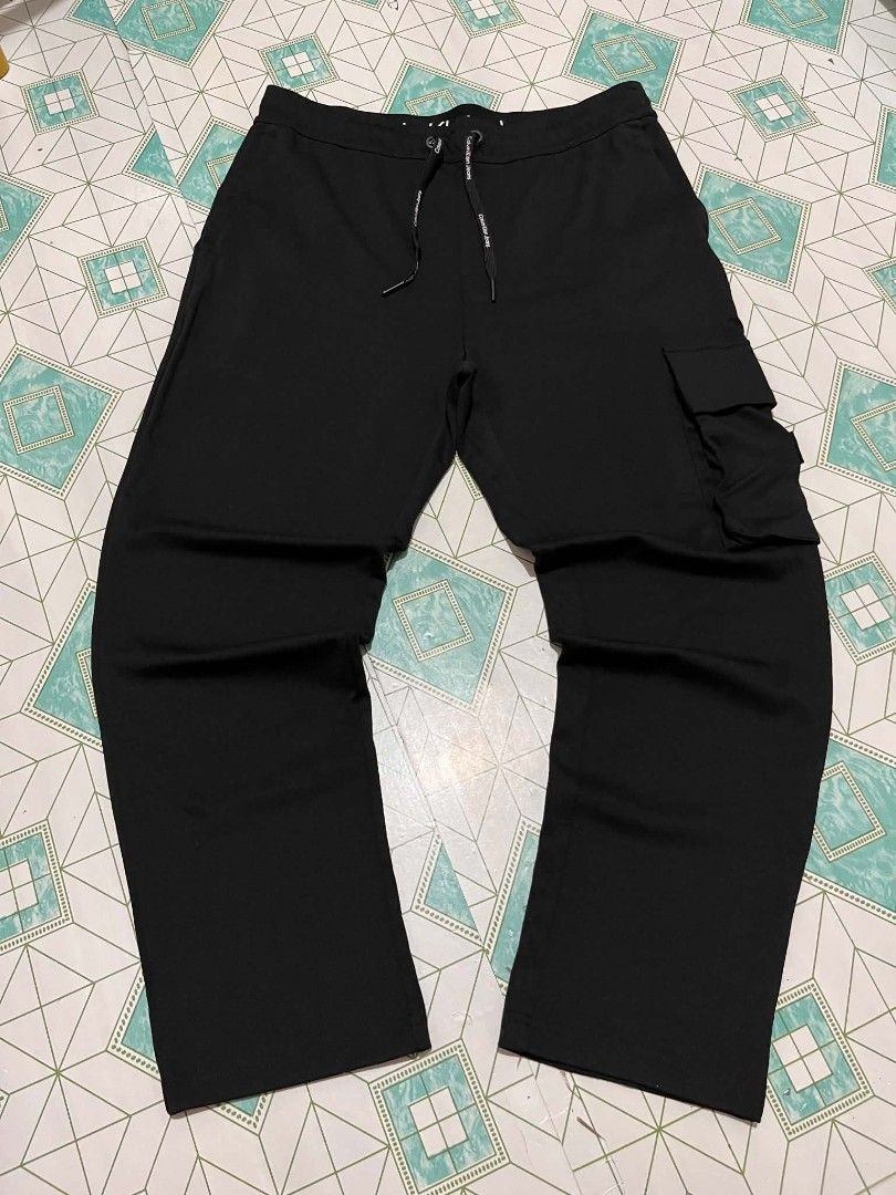 CALVIN KLEIN CARCO PANTS (Category: Joggers) located in Iloilo. Submitted by _lemornosnas02 (Listing ID 1466491277, Image 1). Description: Calvin Klein Jeans black cargo joggers featuring a side cargo pocket with the signature "CK" logo patch +SIZE SMALL ON TAGS +DIMES 16x36 +no issue good as new 10/10 +location iloilo +plus ship via lbc.