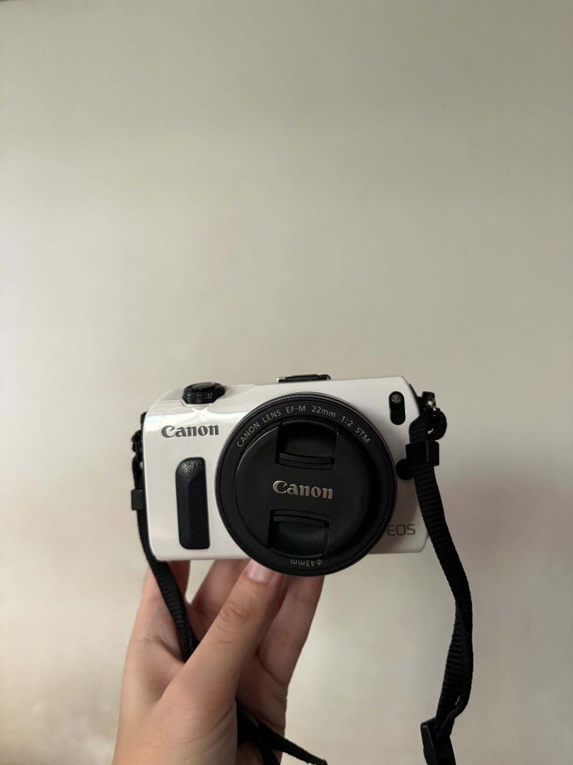 Canon EOS M White (Category: Cameras) located in Taguig. Submitted by cam_demigod (Listing ID 1466459195, Image 1). Description: - Model: Canon EOS M Mirrorless Camera (White) - Lens: EF-M 22mm f/2 pancake lens with cap - Power: Wasabi Power dual battery charger included - Features: Compact and lightweight, perfect for everyday carry and street photography - Condition: Ready to shoot with strap attached.
