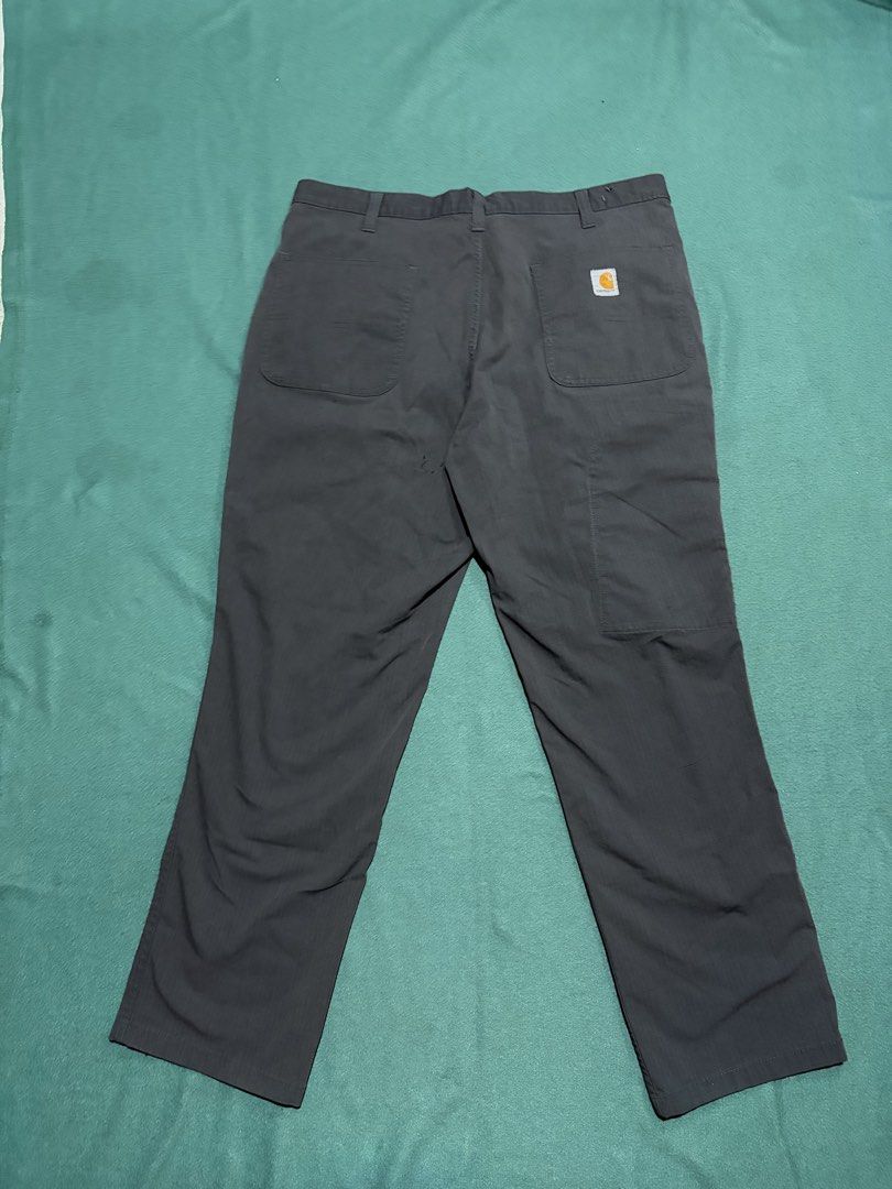 Carousell Carhartt Work Pants Dark Grey (Category: Jeans) located in Guihulngan. Submitted by fbthriftgoodsniace (Listing ID 1466360989, Image 1). Description: - Brand: Carhartt - Color: Dark grey - Size: 21" waist (measured flat) - Material: Sturdy, heavy-duty fabric - Features: Multiple leg utility pockets, belt loops, and classic back pocket logo patch - Condition: Minor signs of wear near the back pocket area - May lints.