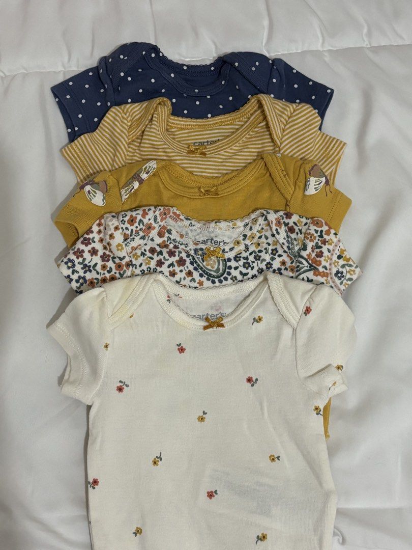 Carter's Onesies Bundle Newborn (Category: Babies & Kids Fashion) located in Makati City. Submitted by max_lilo (Listing ID 1466398068, Image 2). Description: - Brand: Carter's - Size: Newborn - Quantity: Bundle of 5 short-sleeve onesies - Designs: Butterflies, stripes, polka dots, and florals - Material: Soft, breathable cotton - Features: Convenient bottom snap closures for easy diaper changes.