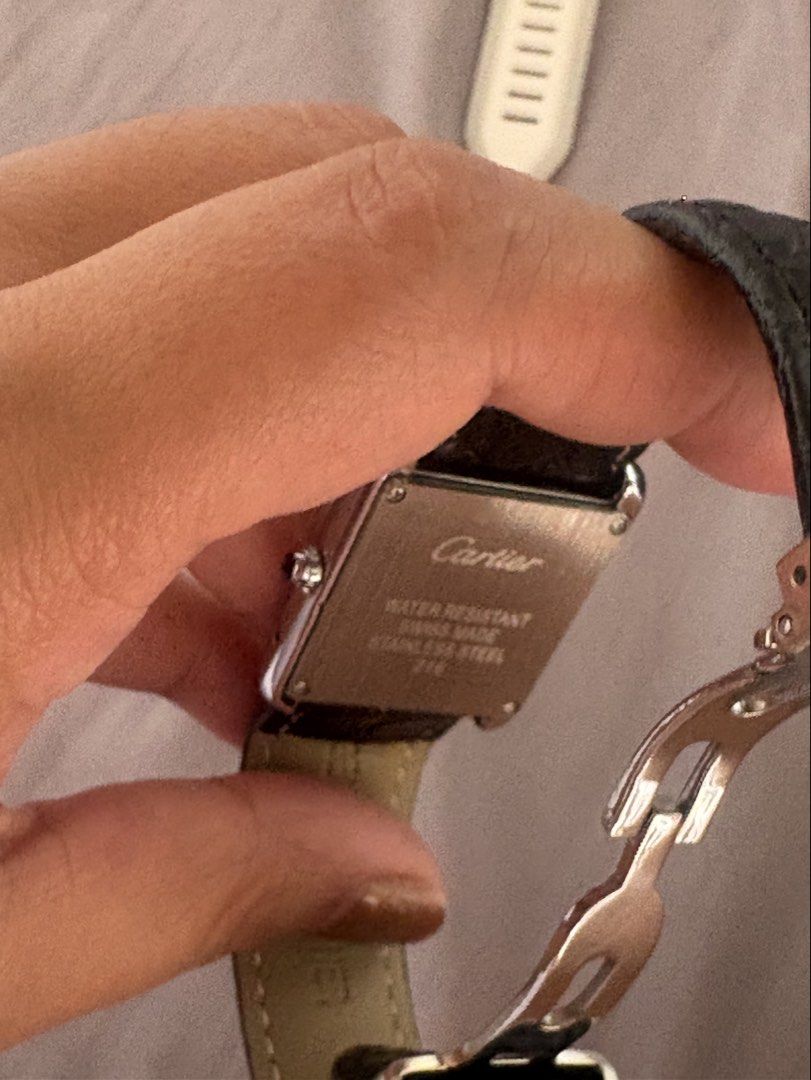 Cartier Tank Watch (Category: Men's Watches) located in Manila. Submitted by mndoxajc (Listing ID 1466064228, Image 3). Description: Stainless steel Cartier Tank watch with white dial and Roman numerals. Black embossed leather strap attached. Blue hands and blue cabochon crown. Case back engraved with Cartier, water resistant, swiss made, stainless steel, and model number 216. Genuine leather stamped on the inner strap. Minimal signs of wear..