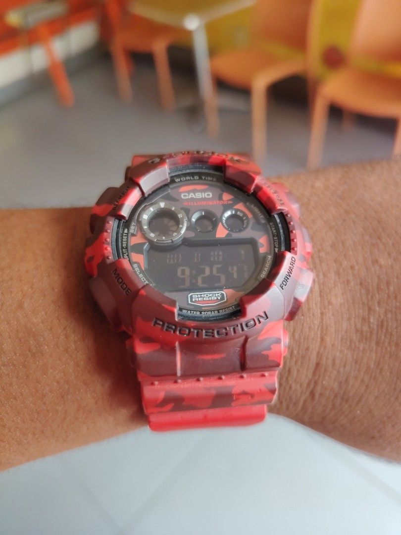 Casio G-Shock Red Camouflage Digital Watch (Category: Men's Watches) located in Las Pinas. Submitted by mitchellestrada20202020 (Listing ID 1466561253, Image 2). Description: - Brand: Casio G-Shock - Design: Bold red and dark red camo pattern - Display: Digital showing day, date, and time - Key Features: World Time, Illuminator, and 20bar Water Resist - Build: Heavy-duty chunky resin with a secure metal buckle - Style: Tactical timepiece, perfect