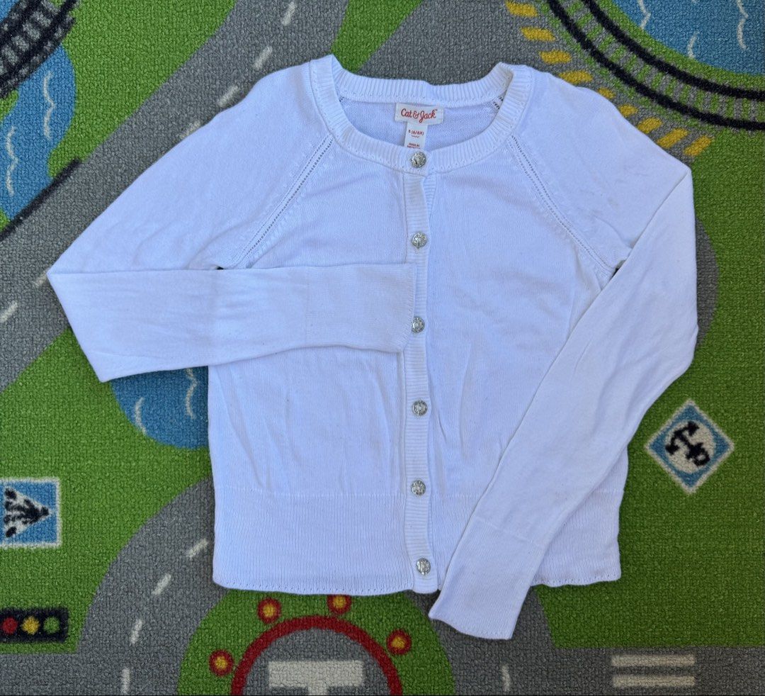 Cat & Jack Cardigan (Category: Babies & Kids Fashion) located in Rizal. Submitted by preloovved (Listing ID 1466455323, Image 1). Description: Cat & Jack white cardigan for girls (Size 6/6X). Features cute sparkly jewel buttons and a soft knit design. Perfect for school or layering over everyday outfits. Preloved, 6yo Meet-up only in GB1 San Mateo, Rizal Shipping fee c/o buyer. Tres Marias or J&T express Payment to be sent to me via BPI/BDO/GCASH