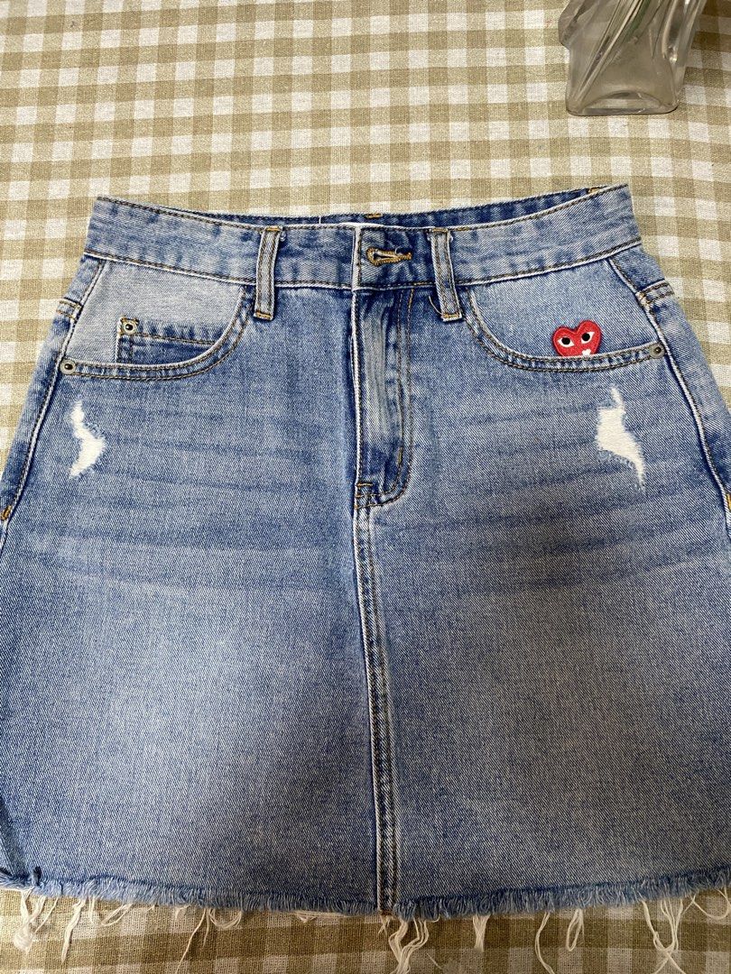 Free SF!!C.d.G. Play Denim Skirt Size M (Category: Skirts) located in Cavite. Submitted by yc.shoppemnl (Listing ID 1466393865, Image 1). Description: - Brand: Comme des Garçons Play - Color: Light blue wash - Size: Medium (M) - Details: Distressed accents near pockets, raw hem, and branded metal button with zip fly - Accent: Iconic small red embroidered heart patch on the right pocket - Condition: Excellent - Waist: size 26 -Length: 16 inches.