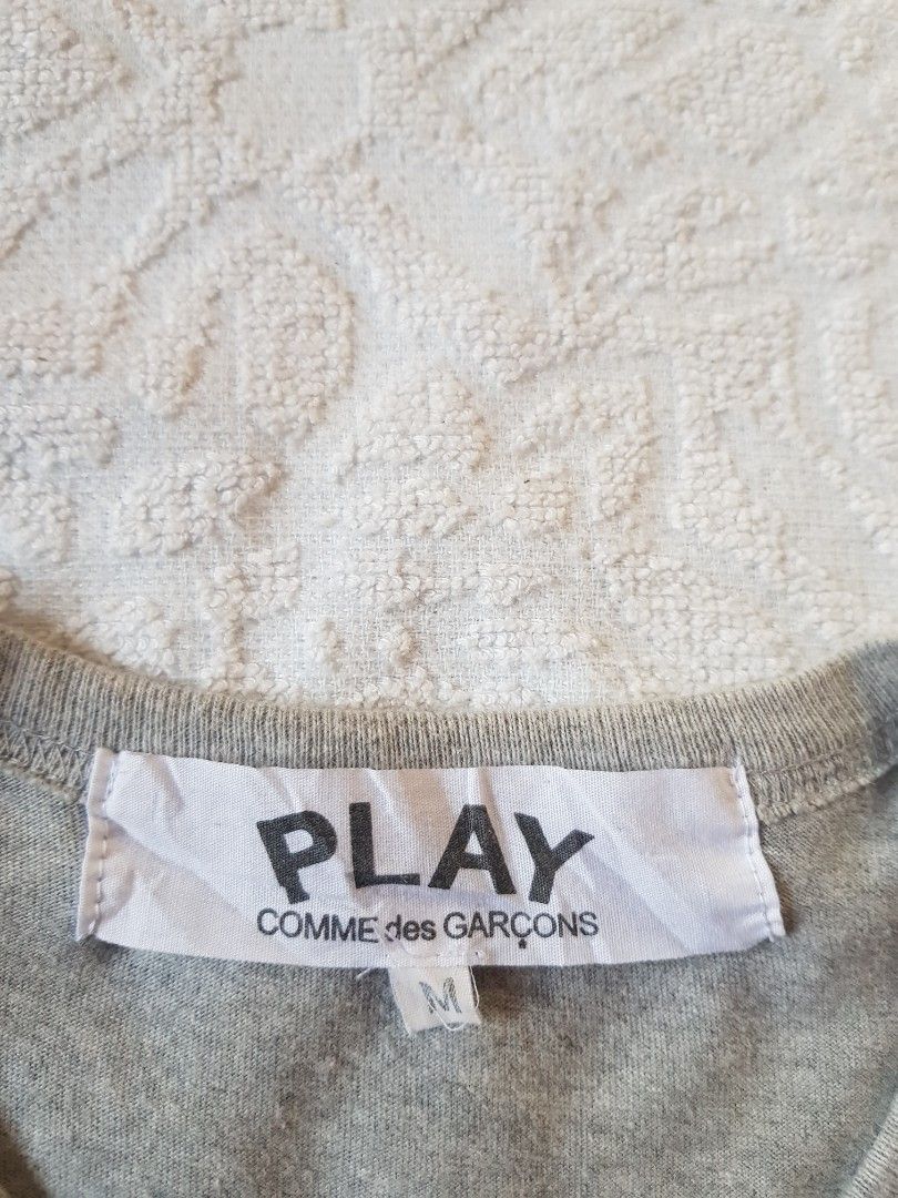 CDG Play Shirt (Category: Luxury Apparel) located in Santo Domingo. Submitted by jcobedoza213916 (Listing ID 1466372760, Image 3). Description: Cdg Play Shirt Unisex Men's & Women's Width 18 Lenght 26.5 Single stitch Sleeve & Hem laylayan size on tag MEDIUM best fit MEDIUM excellent condition color rate 9.7/10 no issue: no pinhole no flaws no discoloration.
