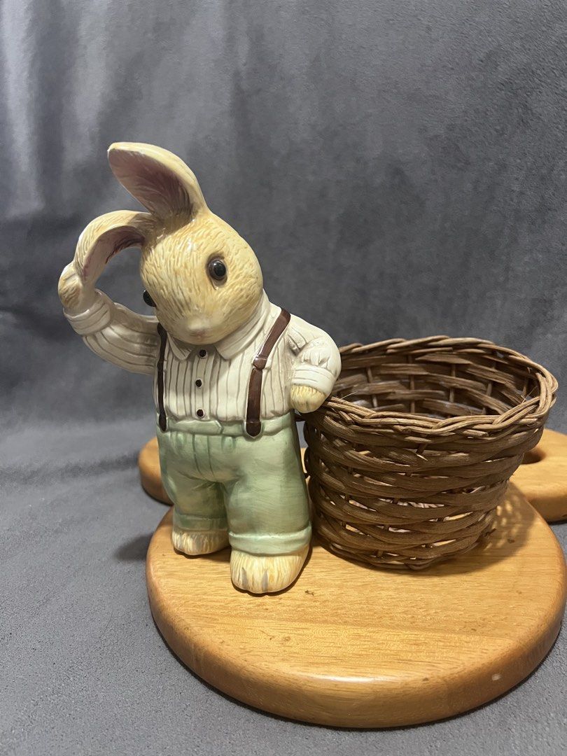 Ceramic Rabbit Figurine with Woven Basket Holder (Category: Designer & Blind Box Toys) located in Las Pinas. Submitted by maple0305 (Listing ID 1466413726, Image 2). Description: - Adorable ceramic rabbit figurine wearing a striped shirt and green overalls - Stands approx. 5.5 inches tall on a sturdy round wooden base - Features a charming design with one ear held up and an attached mini woven wicker basket - Perfect decorative piece for Easter, 