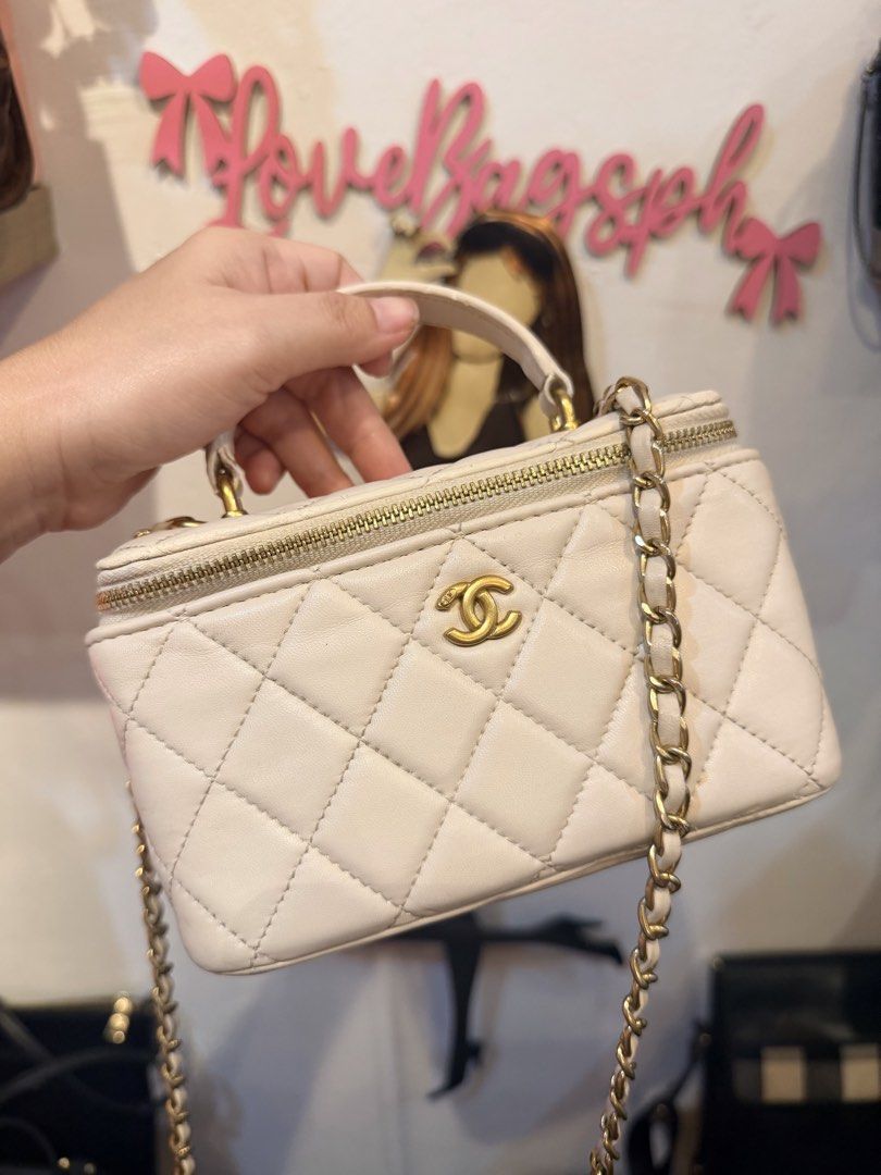 Chanel Quilted Vanity Case with Chain (Category: Luxury Bags & Wallets) located in Dumaguete. Submitted by lovebags.ph (Listing ID 1466394481, Image 3). Description: White quilted leather vanity case from Chanel. Gold-tone hardware with CC logo on the front. Top handle and interwoven chain strap for crossbody wear. Zip around closure keeps items secure. Compact shape holds small daily essentials easily. Clean neutral color goes with many outfits.