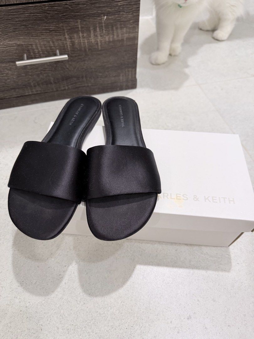 Charles & Keith Black Textured Slides Size 38 (Category: Flats & Sandals) located in Las Pinas. Submitted by felicianoh40332 (Listing ID 1466531898, Image 2). Description: - Brand: Charles & Keith - Style: Black textured slides with a sleek satin-like wide strap - Size: 38 - Design: Slip-on, open toe, flat soles - Condition: Worn a few times; slight dust and minor wear on soles - Inclusion: Original white shoebox.