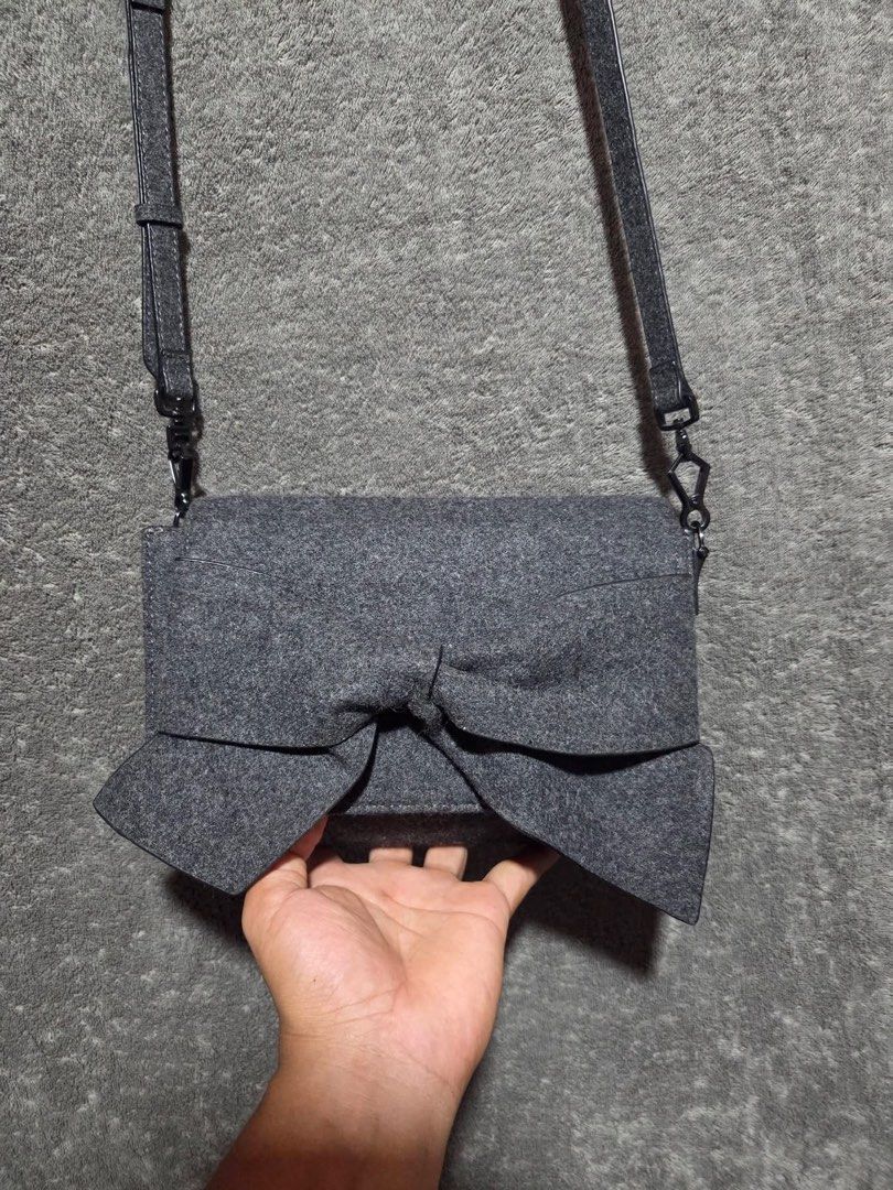 Charles & Keith Grey Felt Bow Crossbody Bag (Category: Cross-body Bags) located in Kidapawan. Submitted by azythrift (Listing ID 1466466379, Image 1). Description: - Brand: Charles & Keith - Color: Elegant grey felt - Design: Large statement bow on front flap with dark gunmetal hardware - Features: Adjustable and detachable shoulder strap with lobster clasps, side snap buttons for adjustable width - Shape: Compact rectangular shape with clean fab