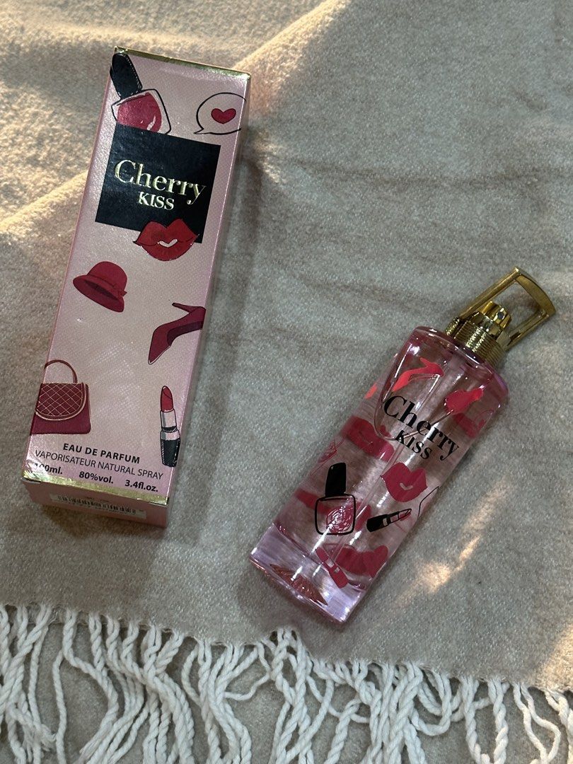Cherry Kiss Eau de Parfum 100ml with Box (Category: Fragrance & Deodorants) located in Manila. Submitted by tenshiii185 (Listing ID 1466527358, Image 1). Description: Cherry Kiss Eau de Parfum in a 100ml spray bottle. Sweet pink packaging covered in lipstick, heels, and lips illustrations. Gold cap with a handle design. Comes with original pink and black box. Full bottle, barely sprayed. Smells sweet and fruity..
