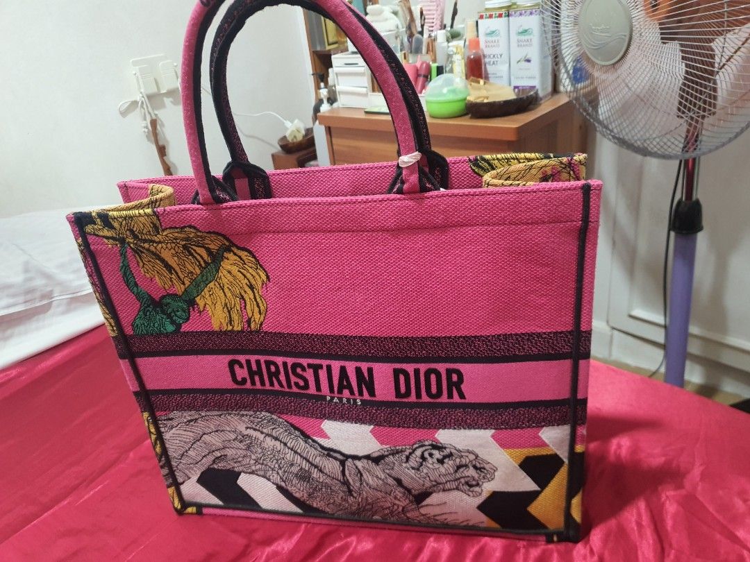 Christian Dior Pink Tote Bag (Category: Luxury Bags & Wallets) located in Binangonan. Submitted by everythingmustgo78 (Listing ID 1466402741, Image 1). Description: - Brand: Christian Dior Paris - Color: Bright pink - Design: Iconic signature lettering with unique embroidered tiger and foliage graphics - Straps: Double top handles with branding detail - Interior: Spacious pink fabric lining with Made In Italy tag - Condition: Excellent / Pristine