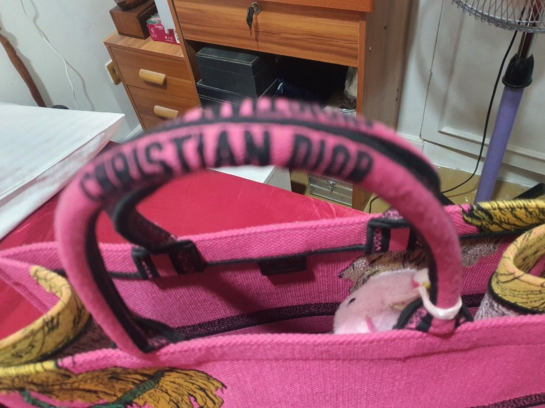 Christian Dior Pink Tote Bag (Category: Luxury Bags & Wallets) located in Binangonan. Submitted by everythingmustgo78 (Listing ID 1466402741, Image 3). Description: - Brand: Christian Dior Paris - Color: Bright pink - Design: Iconic signature lettering with unique embroidered tiger and foliage graphics - Straps: Double top handles with branding detail - Interior: Spacious pink fabric lining with Made In Italy tag - Condition: Excellent / Pristine
