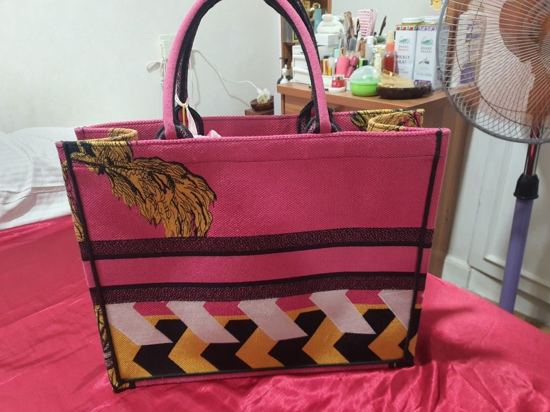 Christian Dior Pink Tote Bag (Category: Luxury Bags & Wallets) located in Binangonan. Submitted by everythingmustgo78 (Listing ID 1466402741, Image 2). Description: - Brand: Christian Dior Paris - Color: Bright pink - Design: Iconic signature lettering with unique embroidered tiger and foliage graphics - Straps: Double top handles with branding detail - Interior: Spacious pink fabric lining with Made In Italy tag - Condition: Excellent / Pristine