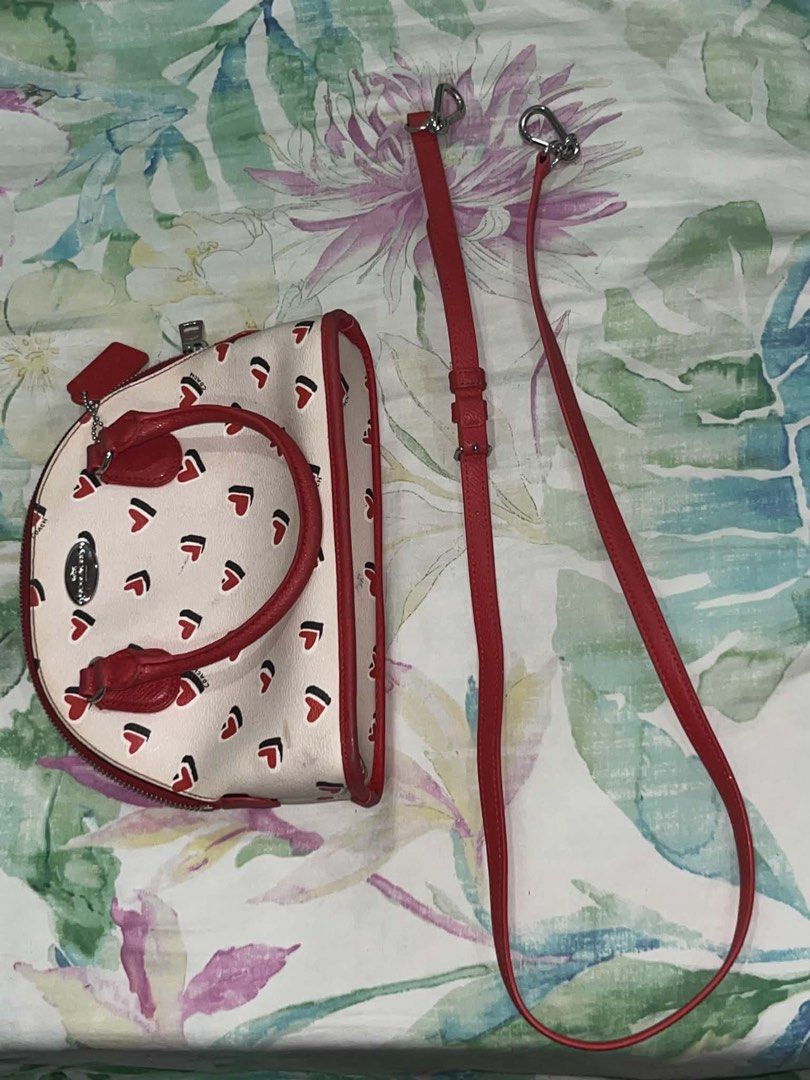 💖 AUTHENTIC COACH MINI SIERRA DOME SATCHEL💖 (Category: Luxury Bags & Wallets) located in Caloocan City. Submitted by isabellz._miwiw (Listing ID 1466339507, Image 2). Description: - Authentic Coach dome satchel - Cream colorway with playful red and black heart pattern - Vibrant red leather dual top handles - Silver-toned hardware with front Coach logo plate - Secure zip-around closure - Includes original Coach hangtag - Compact size, perfect fo