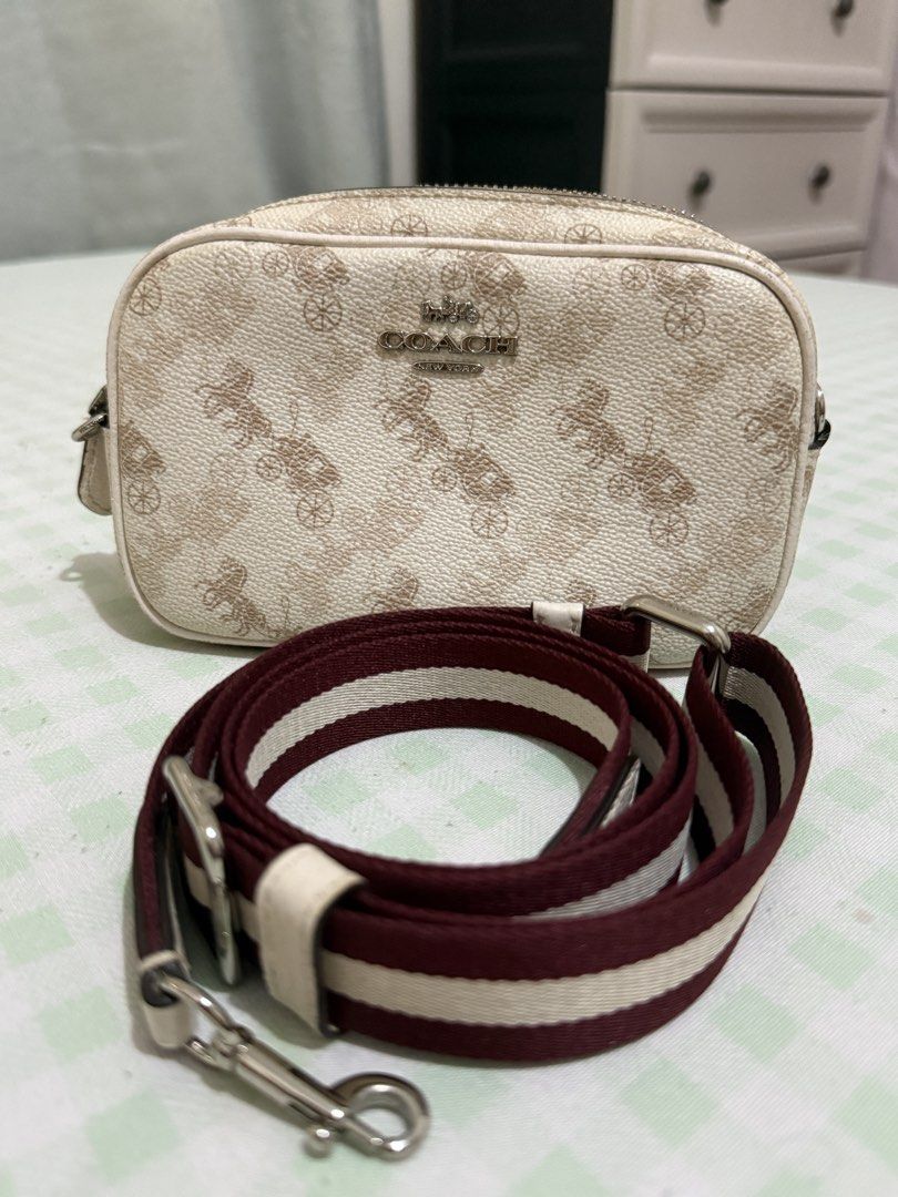 Coach Horse and Carriage Camera Bag (Category: Luxury Bags & Wallets) located in Pasig City. Submitted by xtinegatoc (Listing ID 1466351479, Image 2). Description: - Authentic Coach camera bag with iconic horse and carriage print - Cream coated canvas with subtle tan motifs and metallic silver logo - Secure top zip closure for everyday essentials - Adjustable, detachable burgundy and white striped webbed strap - Silver-tone hardware with easy-cli
