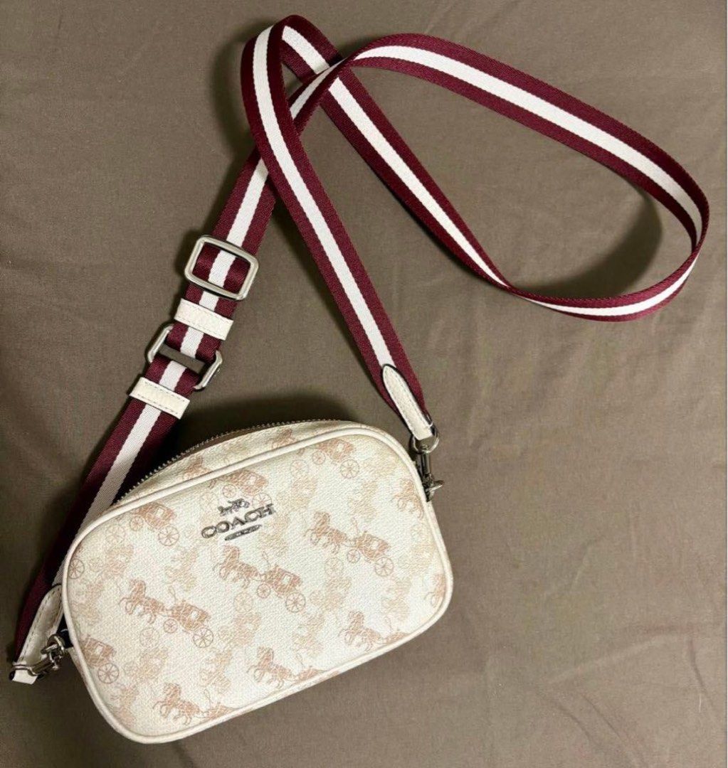 Coach Horse and Carriage Camera Bag (Category: Luxury Bags & Wallets) located in Pasig City. Submitted by xtinegatoc (Listing ID 1466351479, Image 1). Description: - Authentic Coach camera bag with iconic horse and carriage print - Cream coated canvas with subtle tan motifs and metallic silver logo - Secure top zip closure for everyday essentials - Adjustable, detachable burgundy and white striped webbed strap - Silver-tone hardware with easy-cli