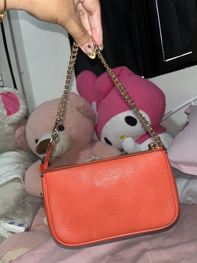 Coach Orange Leather Shoulder Bag with Gold Chain (Category: Luxury Bags & Wallets) located in Liloan. Submitted by sakurumifinds2809 (Listing ID 1466427607, Image 2). Description: Bright orange pebble leather Coach shoulder bag. Gold chain strap and hardware. Zip top closure. Classic Coach logo stamped in gold on the front. Clean pebbled texture. Compact size for daily essentials..