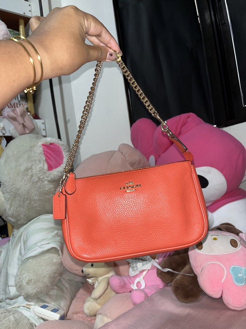Coach Orange Leather Shoulder Bag with Gold Chain (Category: Luxury Bags & Wallets) located in Liloan. Submitted by sakurumifinds2809 (Listing ID 1466427607, Image 1). Description: Bright orange pebble leather Coach shoulder bag. Gold chain strap and hardware. Zip top closure. Classic Coach logo stamped in gold on the front. Clean pebbled texture. Compact size for daily essentials..
