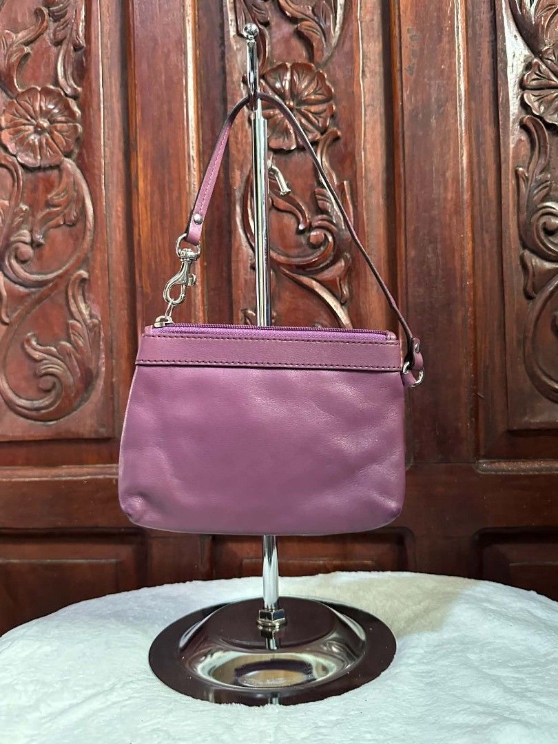 Coach Purple Leather Wristlet Handbag (Category: Luxury Bags & Wallets) located in Pasacao. Submitted by kishhuschka (Listing ID 1466429376, Image 2). Description: - Brand: Coach -Authentic 💯 - Color: Rich purple leather with light grey fabric lining - Design: Stylish ruched front with silver-toned metal Coach logo and hardware - Closure & Strap: Secure zip top closure with a convenient detachable wrist strap - Interior: Compact size ideal for c