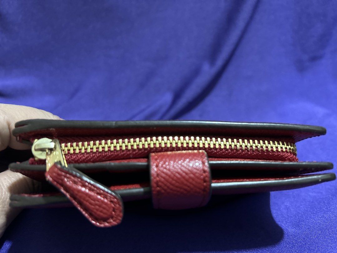 Coach Red Leather Medium Wallet (Category: Wallets & Card holders) located in Cavite. Submitted by mgstuffboutique (Listing ID 1466466290, Image 3). Description: - Brand: Coach New York - Material: Red pebbled leather with gold-toned hardware - Closure: Secure snap strap - Interior features: ID window, multiple card slots, and zippered section for coins/bills - Design: Structured, clean lining, and compact size that easily fits in smaller bags - 