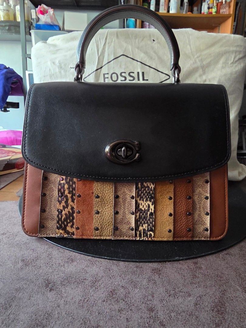 Coach Structured Top Handle Bag (Category: Luxury Bags & Wallets) located in Mandaluyong City. Submitted by artlin04 (Listing ID 1466388598, Image 1). Description: - Authentic Coach top handle bag - Striking black and multi-color panel leather design with chic stud details - Secure flap front with iconic turn-lock closure - Luxurious suede interior lining equipped with a zippered side pocket and Coach creed patch - Versatile styling: comes with a