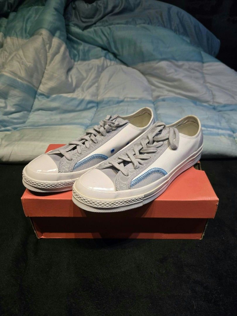 Converse Chuck 70 Low Grey White Blue (Category: Sneakers) located in Indang. Submitted by yoowhann (Listing ID 1466385914, Image 1). Description: - Brand: Converse - Style: Low-top sneakers - Color: Grey and white with light blue contrast stitching - Features: Rubber toe cap, flat laces, textured midsoles - Condition: Clean uppers and pristine outsoles - Packaging: Original orange shoe box included.