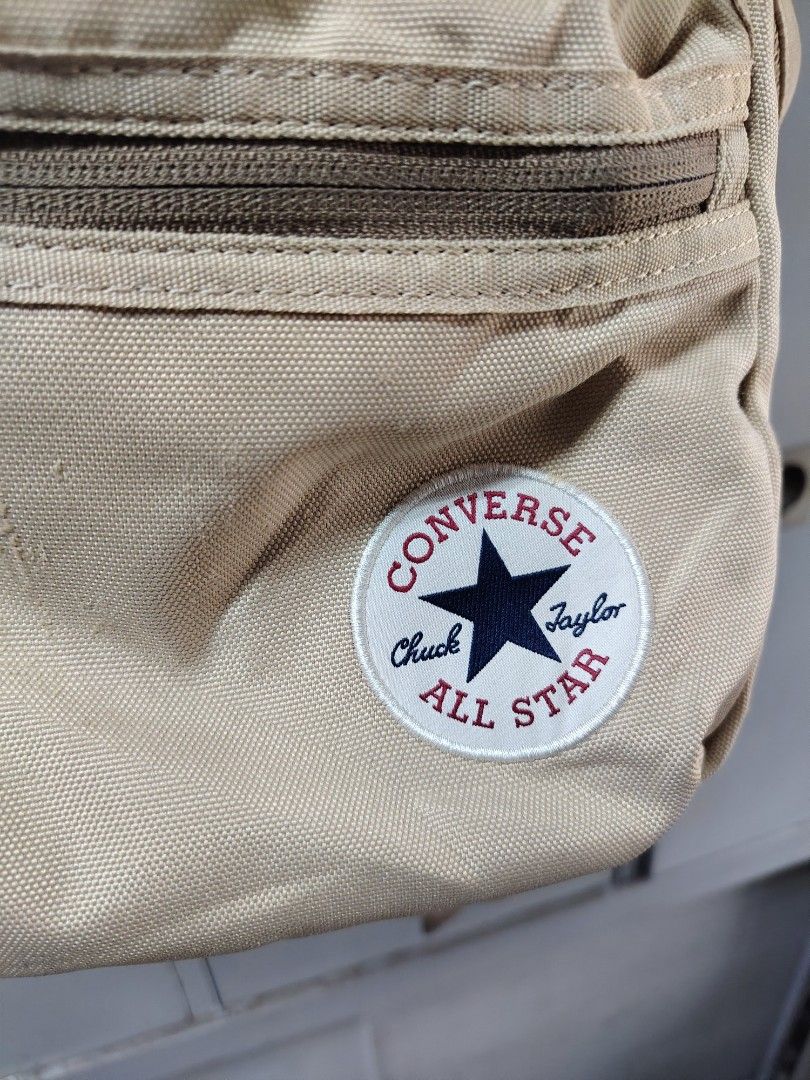 Converse Chuck Taylor All Star beige backpack (Category: Backpacks) located in Davao. Submitted by dareyl_121422 (Listing ID 1466337272, Image 2). Description: - Brand: Converse Chuck Taylor - Color: Neutral beige / khaki - Material: Sturdy canvas - Storage: Multiple zippered compartments and front pocket - Logo: Classic circular Converse logo patch on the front - Comfort: Breathable mesh back padding - Straps: Adjustable shoulder straps with sty