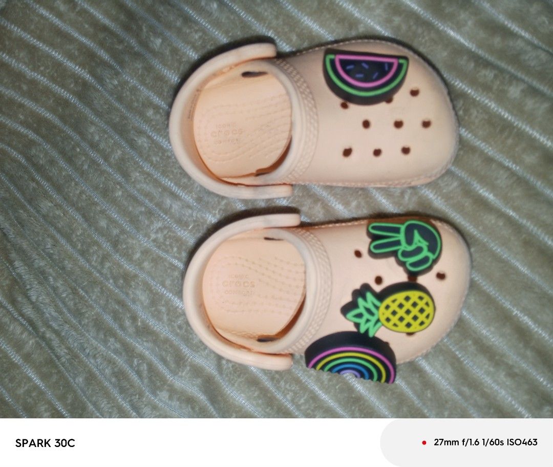 Crocs Classic Clogs Kids Size C4 Peach With Jibbitz (Category: Babies & Kids Fashion) located in Muntinlupa City. Submitted by bravedolphin.c112ad (Listing ID 1466428932, Image 2). Description: - Size: Toddler C4 - Color: Peach - Includes attached Jibbitz: Pineapple, watermelon, rainbow, peace sign - Features: Slip-on design with secure pivoting heel strap and Iconic Crocs comfort insoles - Condition: Light dirt on soles from previous wear, other
