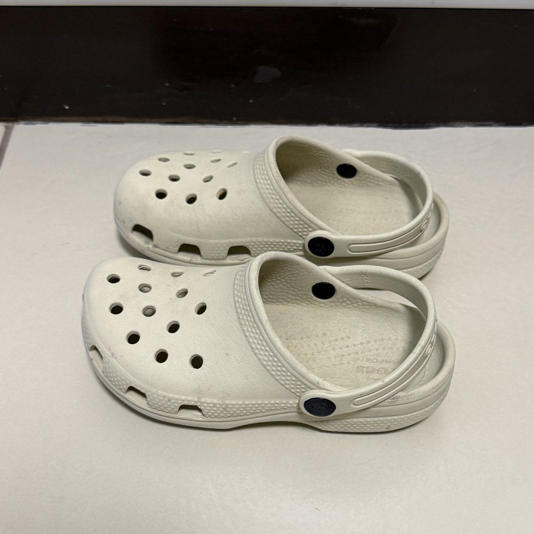 Crocs Classic Clogs Off White Size C12 (Category: Babies & Kids Fashion) located in Taguig. Submitted by lessthangel_ (Listing ID 1465224232, Image 1). Description: - Item: Crocs Classic Clogs - Color: Bone / Off-White - Size: C12 (Kids) - Design: Slip-on with ventilation ports and pivoting heel strap - Condition: Pre-loved with moderate scuffs and dirt marks from daily wear - Perfect for daily casual wear, playground, or beach trips -Not thrifte