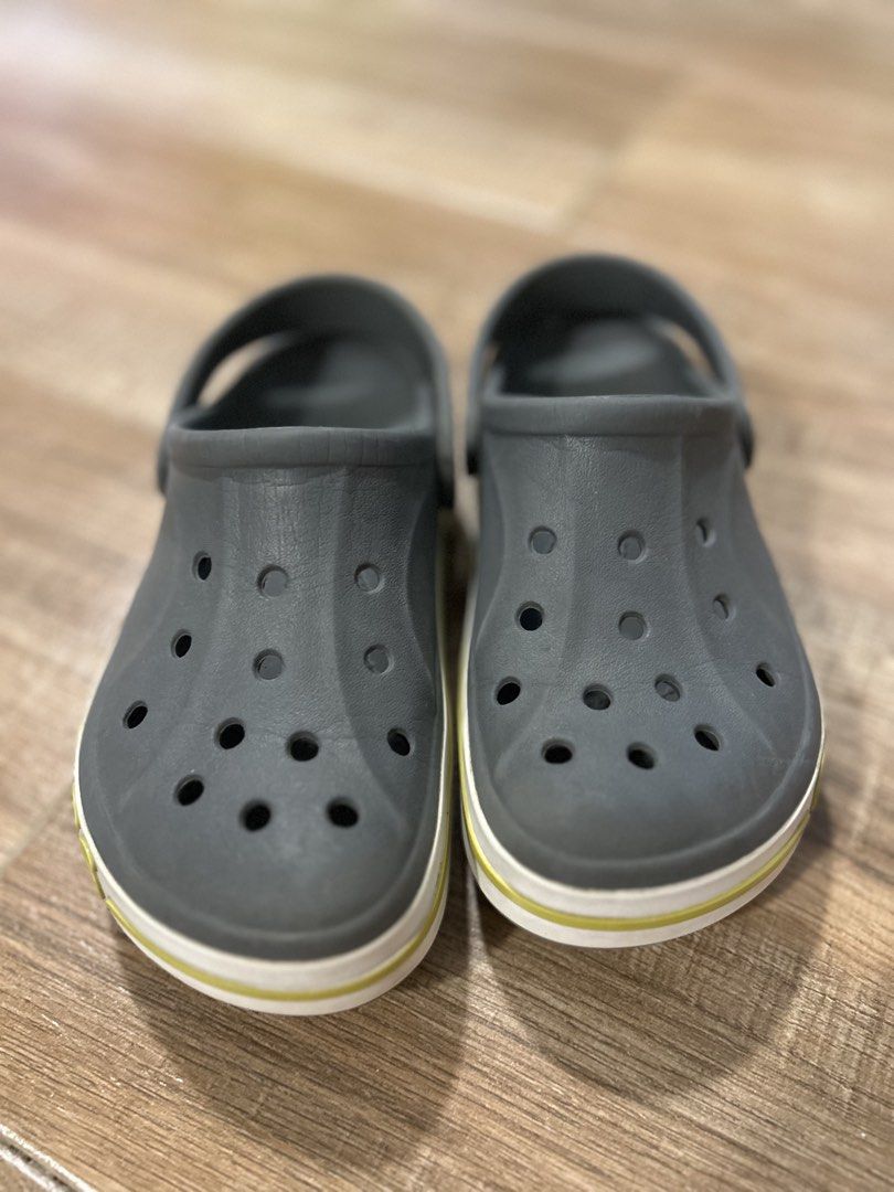 Crocs Crocband Clogs Grey Kids Size J1 (Category: Babies & Kids Fashion) located in San Fernando. Submitted by gisellelynn77 (Listing ID 1466562273, Image 1). Description: - Authentic Kids Crocs Crocband Clogs - Color: Grey with white and yellow midsole stripe - Size: J1 - Condition: Excellent, minimal wear on soles with fully intact tread - Features: Ventilation holes, pivoting heel strap, and iconic side logo - Easy to wash, quick-drying, and s