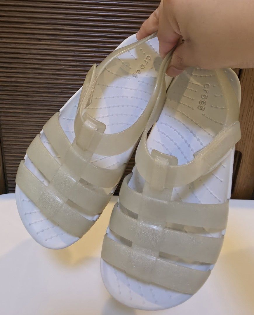 Crocs Jelly Sandals White Size 13 (Category: Babies & Kids Fashion) located in San Fernando. Submitted by iris_dj23 (Listing ID 1466359699, Image 2). Description: - Color/Style: Translucent glitter white jelly sandals - Size: 13 (printed on outsole) - Features: Adjustable ankle strap, cutout strap design, and textured footbed - Condition: Soles show light wear from normal use - Perfect for casual wear and easy to clean.