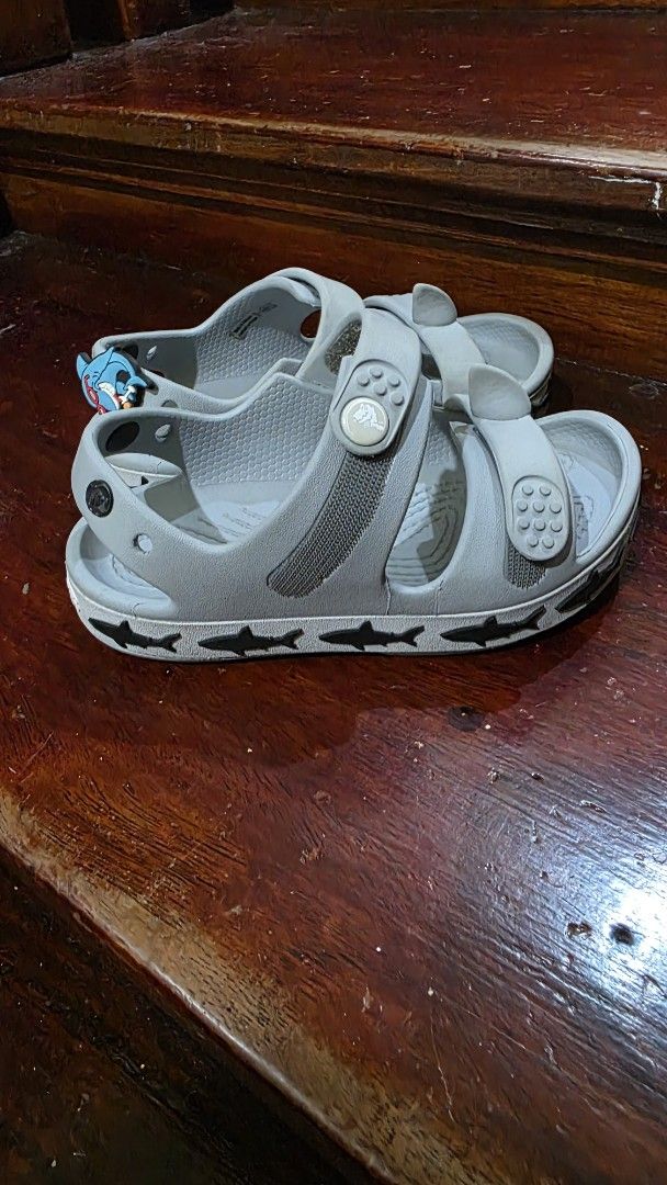Crocs Toddler C10 Shark Sandals Grey (Category: Babies & Kids Fashion) located in Valenzuela. Submitted by bella_onez (Listing ID 1466445976, Image 1). Description: - Size: Toddler C10 - Color: Grey - Fun shark design along the midsole with a detachable shark Jibbitz charm - Dual strap closure for an easy, adjustable fit - Textured footbed for better grip and safety - Ideal for playground adventures or beach days - Trusted seller, fast shipping a