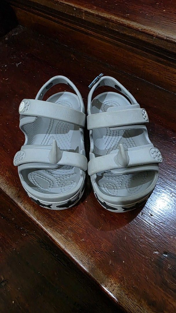 Crocs Toddler C10 Shark Sandals Grey (Category: Babies & Kids Fashion) located in Valenzuela. Submitted by bella_onez (Listing ID 1466445976, Image 2). Description: - Size: Toddler C10 - Color: Grey - Fun shark design along the midsole with a detachable shark Jibbitz charm - Dual strap closure for an easy, adjustable fit - Textured footbed for better grip and safety - Ideal for playground adventures or beach days - Trusted seller, fast shipping a